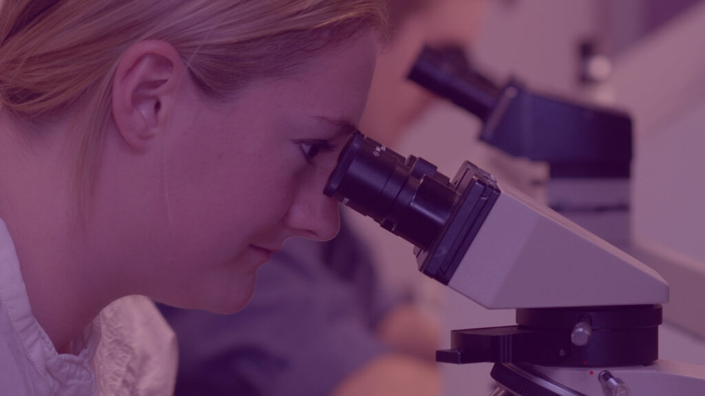 woman staring into microscope