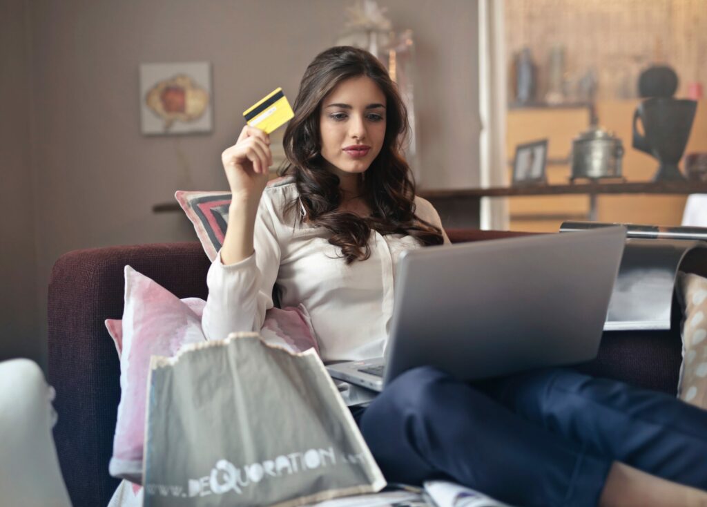 woman sitting with laptop and ordering shopping online